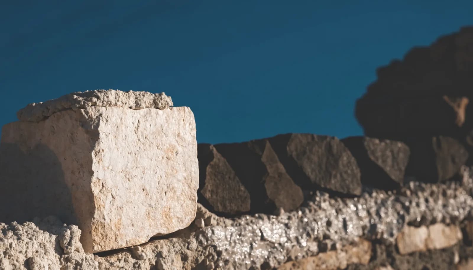 A single squared foundation stone set as the first course of a wall.